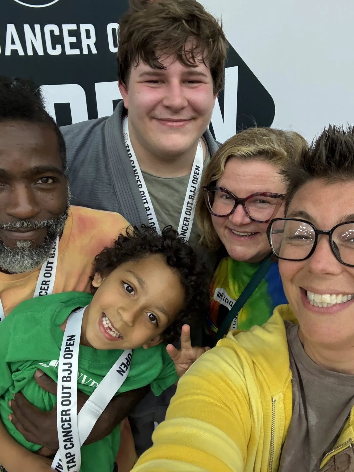 A family and coaches smiling together at a Brazilian Jiu Jitsu event